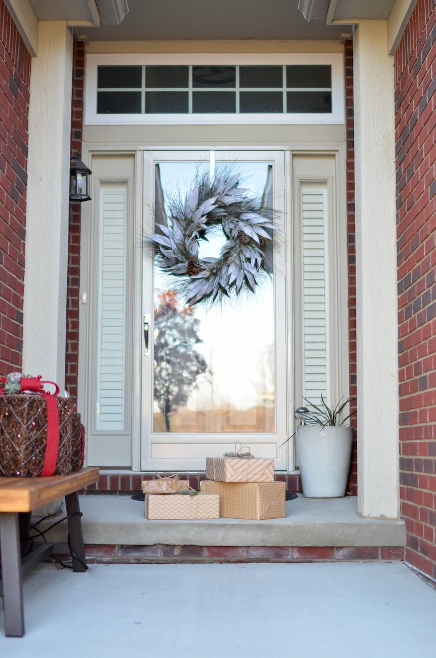 four brown gift boxes near a glass paneled door with wreath